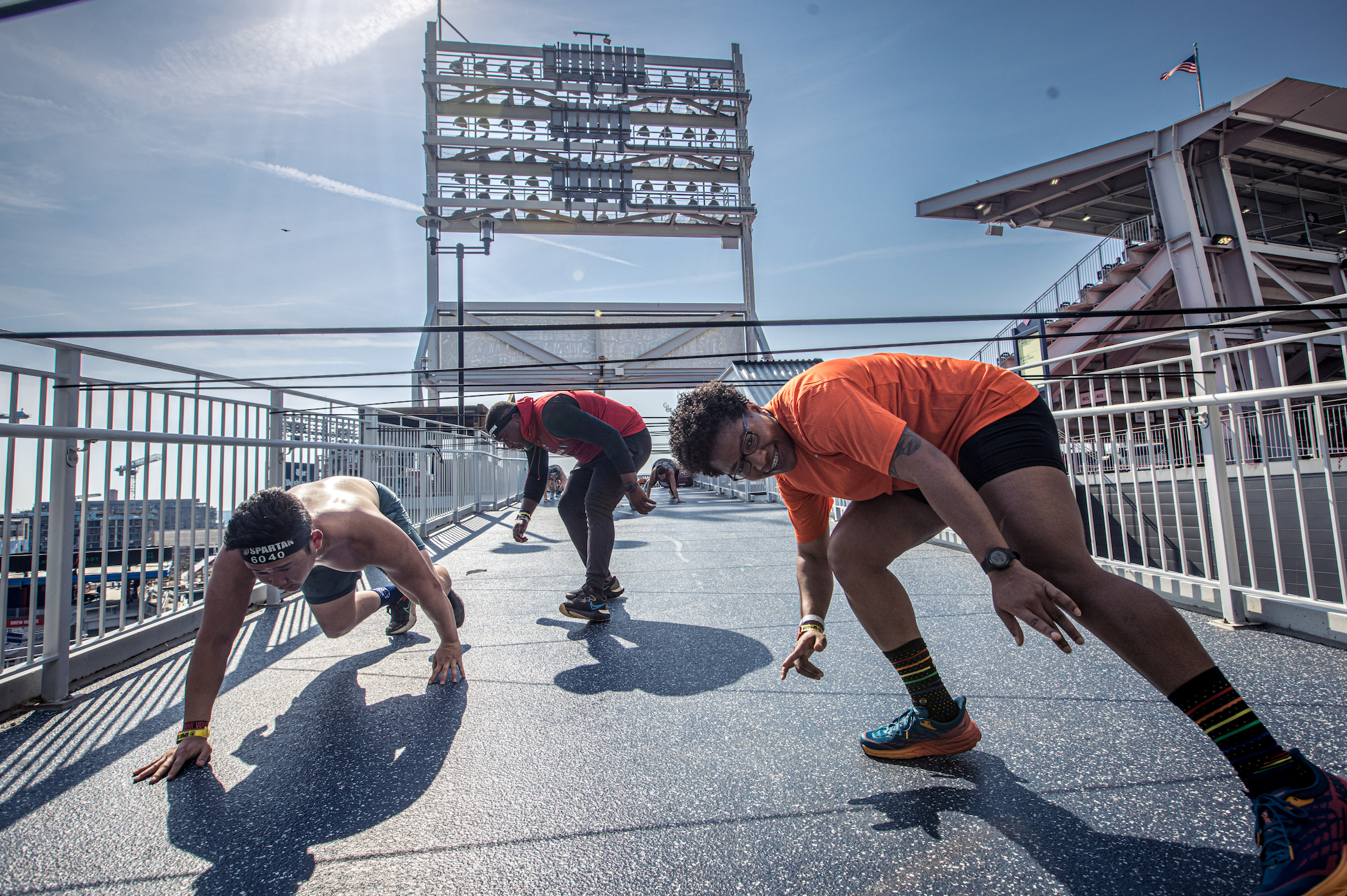 a spartan racer completing the cord crawl obstacle at a stadion race
