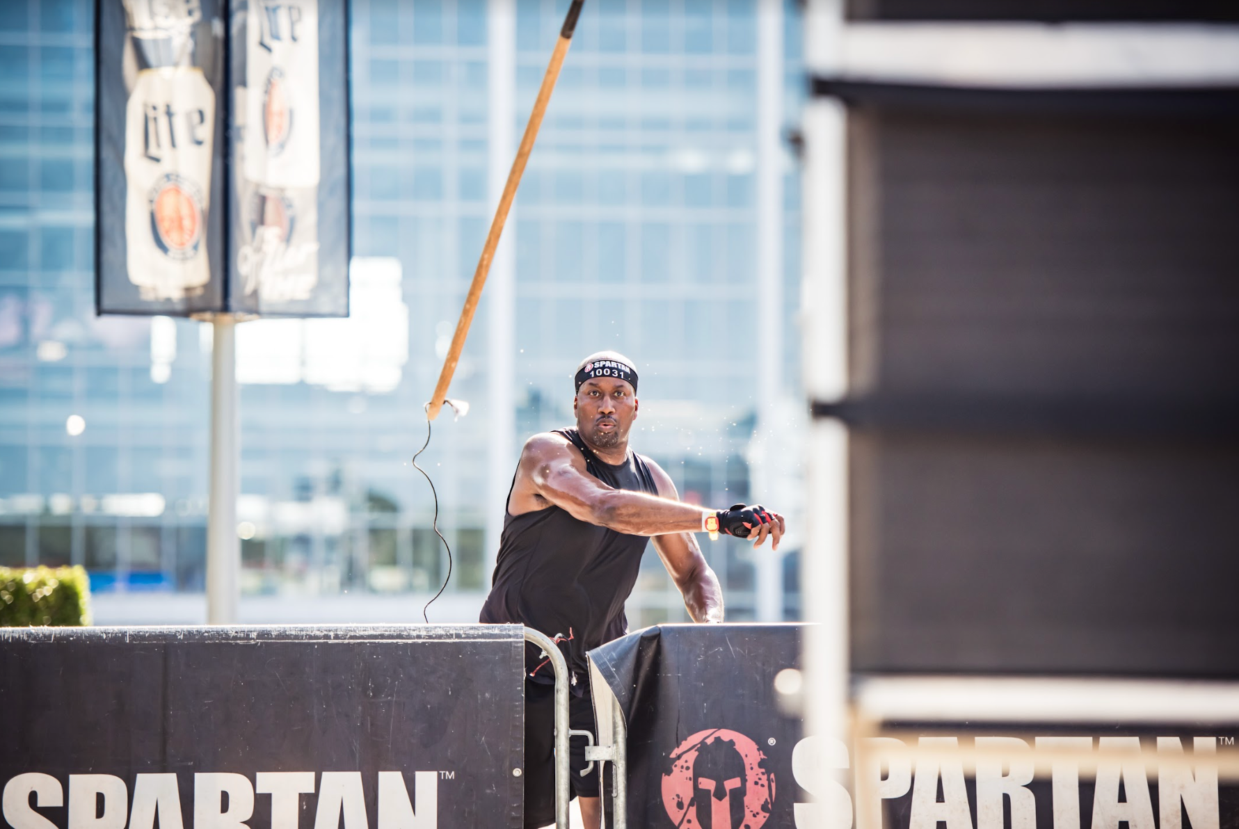 a spartan racer completing the spear throw obstacle at a stadion race